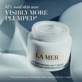 La Mer The Moisturizing Soft Cream jar on silk fabric, with 87% visibly more plumped claim text overlay