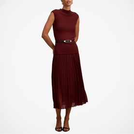 Model wearing Forever New Burgundy Rose sleeveless midi dress with pleated skirt and gold-tone oval belt buckle, styled with strappy heels