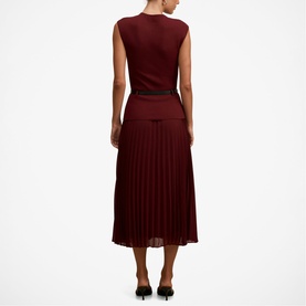 Model wearing Forever New Burgundy Rose sleeveless midi dress with pleated skirt and contrast black waistband, back view