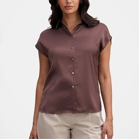 Model wearing Forever New Chocolate Brownie satin short-sleeve button-up shirt, styled with stone wide-leg trousers.