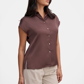 Model wearing Forever New Chocolate Brownie short sleeve satin blouse with button front, styled with cream wide-leg trousers