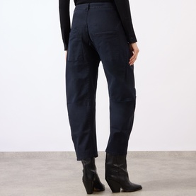 Model wearing Nili Lotan navy cotton cargo trousers, rear view, styled with a black long-sleeve top and brown ankle boots.