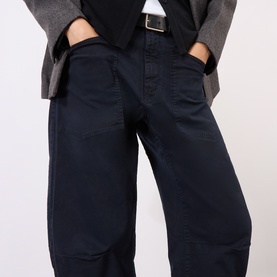 Model wearing Nili Lotan navy wide-leg trousers with patch pockets, styled with a grey blazer and black belt.