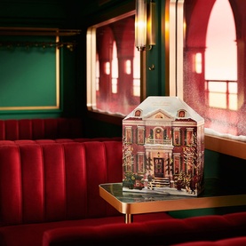 Rituals Classic Advent Calendar in festive house-shaped box displayed on table in red-velvet restaurant setting