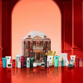 Rituals Classic Advent Calendar displayed open with 24 beauty products arranged in front of festive house-shaped box on red surface