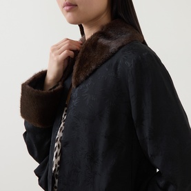 Model wearing Rixo London black viscose jacket with brown faux fur collar and cuffs, leopard print trim detail visible at front edge.