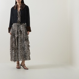 Model wearing Rixo London black viscose jacket with faux fur cuffs, styled with leopard print maxi dress and black heeled sandals.