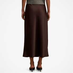 Model wearing Forever New chocolate satin midi skirt, styled with a grey knit top and black heeled mules, rear view.