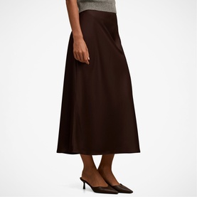 Model wearing Forever New chocolate midi A-line skirt, styled with grey top and black heeled mules.