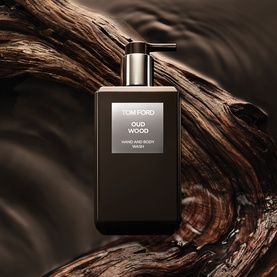 Tom Ford Oud Wood Hand and Body Wash pump bottle in dark glass, styled against rich wood grain background