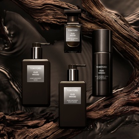 Tom Ford Oud Wood Hand and Body Wash displayed with matching Oud Wood body care collection on dark wood background.