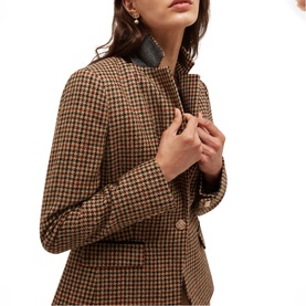 Model wearing Hobbs brown multi houndstooth blazer with button-front fastening, styled with pearl drop earrings