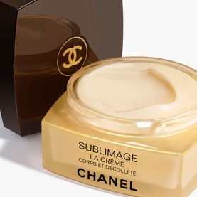 Chanel Sublimage La Cr&egrave;me Ultimate Body Cream open jar showing rich cream texture, with dark brown gift box behind