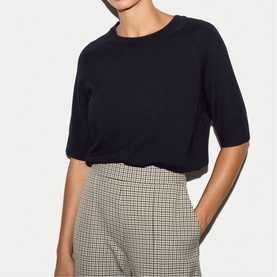 Model wearing Jigsaw navy short-sleeve knit top, styled with houndstooth check trousers.