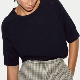 Model wearing Jigsaw navy short-sleeve knit top, styled with a houndstooth check mini skirt.