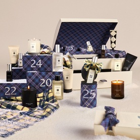 Jo Malone 25 Day Luxury Fragrance Advent Calendar with navy tartan-wrapped numbered boxes, candles, and colognes displayed open.