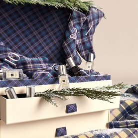 Jo Malone 25 Day Luxury Fragrance Advent Calendar in blue tartan box with miniature bottles nestled inside, decorated with pine sprigs