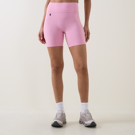 Model wearing On Running Magnolia shorts in pink, styled with white ankle socks and grey trainers