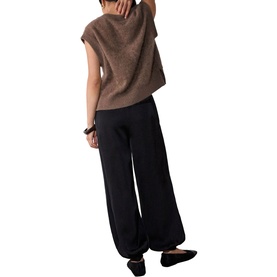 Model wearing Whistles black wide-leg trousers, shot from behind, styled with a brown sleeveless knit top and black flat shoes.
