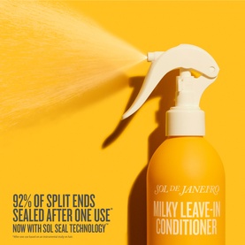 Sol De Janeiro Milky Leave-In Conditioner spray bottle in yellow, with mist spray action shown against yellow background.