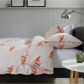 The Lyndon Company Duvet Set in white with repeat orange fox print, styled on a double bed with matching pillowcases
