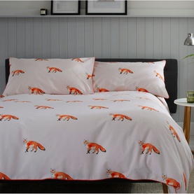 The Lyndon Company duvet set in white with repeating orange fox print, shown dressed on a double bed with two matching pillowcases.
