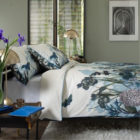 The Lyndon Company Blue Duvet Set styled on a double bed with floral and butterfly print, coordinating pillowcases, in a serene bedroom setting.