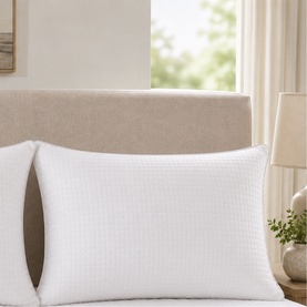 The Soft Bedding Co white pillow with textured quilted cover, styled on a bed with neutral linen headboard