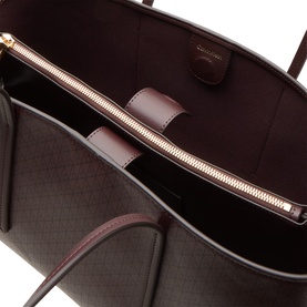 Calvin Klein Fudge AOP Tote Bag interior view showing gold-tone zip pocket and dark plum structured lining
