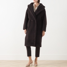 Model wearing Max Mara Main dark brown alpaca-wool blend longline coat with wide lapels, styled with cropped trousers and nude heels.