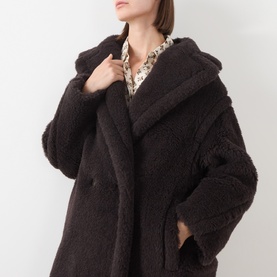 Model wearing Max Mara Main dark brown alpaca wool teddy coat with wide lapels, styled over a floral shirt.