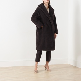 Model wearing Max Mara Main dark brown alpaca-blend teddy coat, styled with black tapered trousers and nude heels.