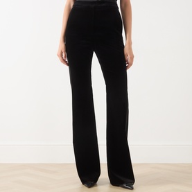 Model wearing Max Mara Studio black velvet flared trousers with high waist, styled with black heeled shoes