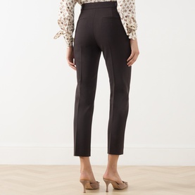Model wearing Max Mara Main dark brown slim-leg wool trousers, styled with a floral blouse and nude heels, rear view.