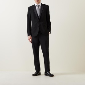 Model wearing Remus Single-Breasted Tuxedo Jacket in black with matching trousers, grey waistcoat, white shirt and black loafers.