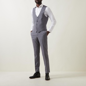 Model wearing Remus Luca Suit Trousers in grey with matching grey waistcoat, white shirt and black dress shoes.
