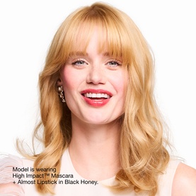 Model wearing Clinique Lash Definition & Black Honey Lip Makeup Gift Set; bold red-berry lip and defined lashes, styled with crystal drop earrings