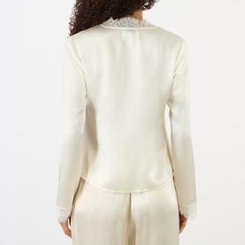 Model wearing Ganni egret satin blouse, rear view, with lace collar detail, styled with matching wide-leg trousers