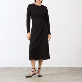 Model wearing MeiMeij nero midi dress with long sleeves and twist-front detail, paired with black strappy heels.