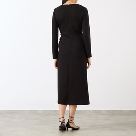 Model wearing MeiMeij nero midi dress, long sleeves, wrap-style back detail, paired with black strappy heels. Back view.