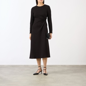 Model wearing MeiMeij nero midi dress with long sleeves and side-wrap detail, styled with black strappy heels and clutch bag.