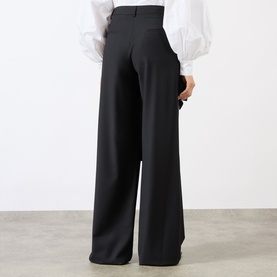 Model wearing MeiMeij nero wide-leg trousers, back view, styled with a white puff-sleeve blouse.