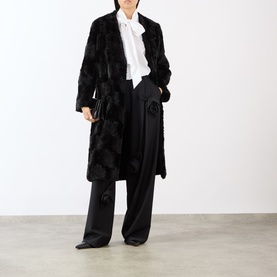 Model wearing MeiMeij Nero wide-leg trousers styled with a black textured coat and white tie-neck blouse.