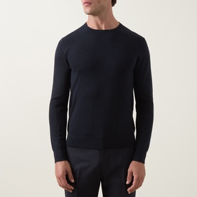 Model wearing Tiger of Sweden Connor RWS Merino Sweater in Light Ink, crew neck fine knit with ribbed trims, styled with navy trousers.