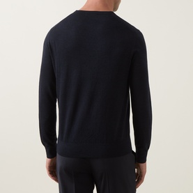 Model wearing Tiger of Sweden Connor RWS Merino Sweater in Light Ink, rear view showing crew neck and ribbed trims, styled with navy trousers.