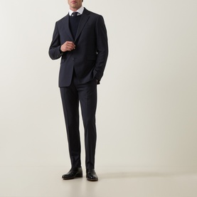 Model wearing Tiger of Sweden Connor RWS Merino Sweater in Light Ink, styled with navy suit and white shirt.
