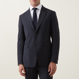 Model wearing Tiger of Sweden Dark Ink suit jacket, styled with white shirt and navy tie, two-button front, notch lapels