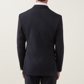 Model wearing Tiger of Sweden Suit Jacket in Dark Ink, rear view showing tailored back seam and notched collar, styled with white shirt.