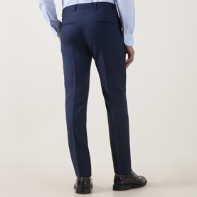 Model wearing Tiger of Sweden sea blue suit trousers, styled with a light blue shirt and black leather shoes, rear view.