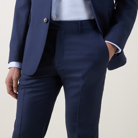 Model wearing Tiger of Sweden suit trousers in sea blue, styled with matching blazer and light blue shirt, slim tailored fit